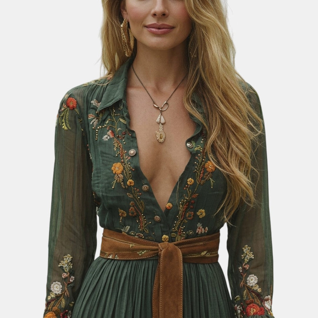 Close-up detail of the Marlena Maxi Dress Floral-Embroidered Long-Sleeve Boho in green, featuring the deep V-neckline, embroidered floral pattern, braided waist belt, and elegant boho styling. Designed by Bella Hudson.