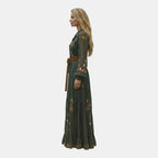 Side view of the Marlena Maxi Dress Floral-Embroidered Long-Sleeve Boho in green, showcasing the flowing maxi silhouette, long sleeves, braided waist belt, and embroidered floral accents. Designed by Bella Hudson.