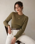 Maya Green ribbed knit sweater with crew neck and lantern sleeves, styled seated with cream trousers and a brown belt.