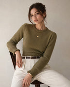 Maya Green ribbed knit sweater with crew neck and lantern sleeves, styled seated with cream trousers and a brown belt.