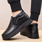 Mia Black slip-on ankle boots with plush lining, elastic side panels, and textured soles, shown on feet