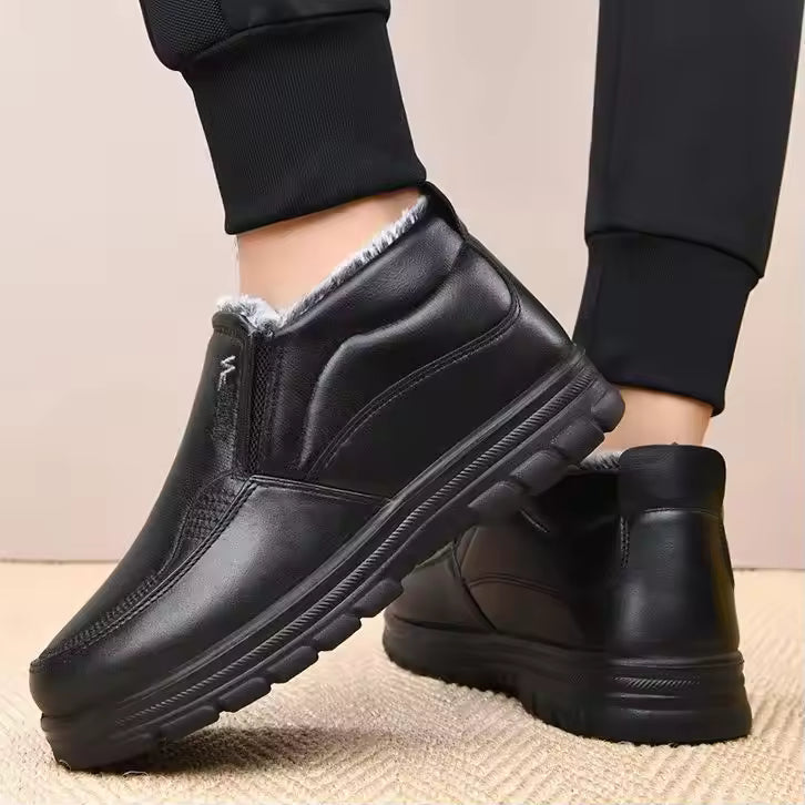 Mia Black slip-on ankle boots with plush lining, elastic side panels, and textured soles, shown on feet