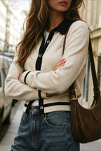 Mia Off White knit cardigan shown close up with black contrast placket, point collar, and striped cuffs styled with denim and a brown shoulder bag.
