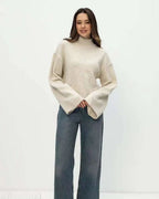 Mila Beige mock-neck sweater styled with wide-leg jeans in a full-length front view.