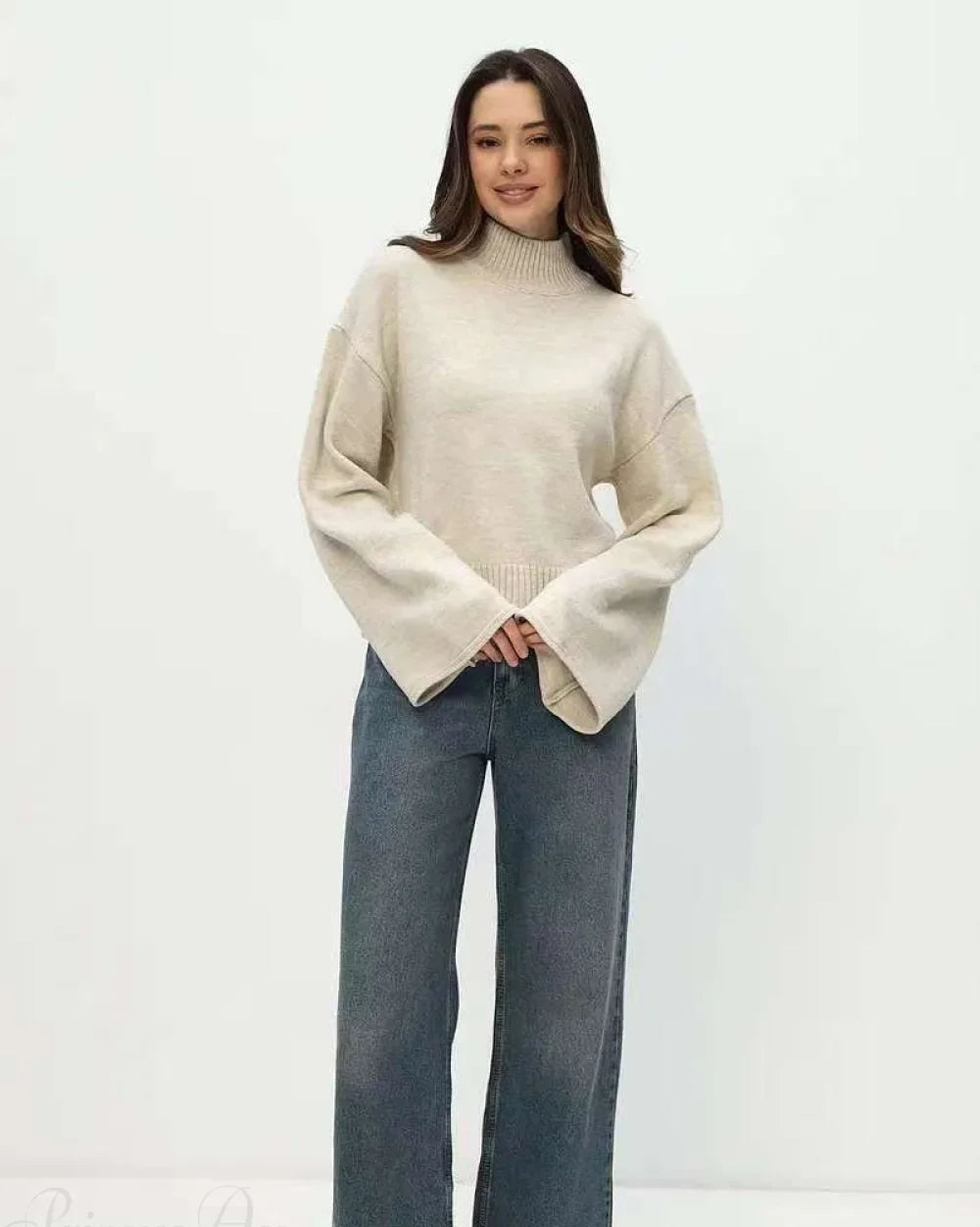 Mila Beige mock-neck sweater styled with wide-leg jeans in a full-length front view.
