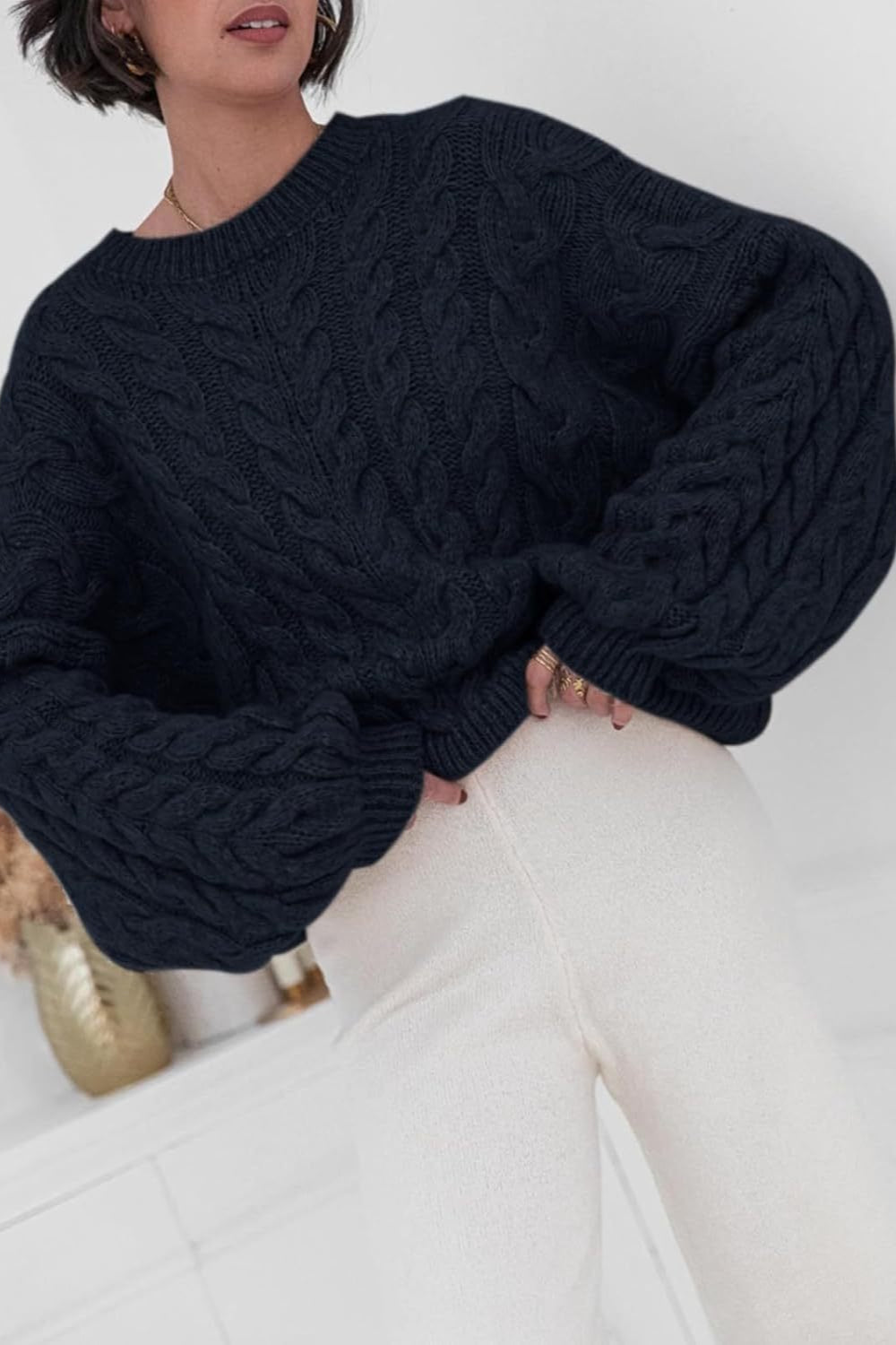 Mila Black cable-knit crewneck sweater shown close up with cable texture and dropped shoulders.