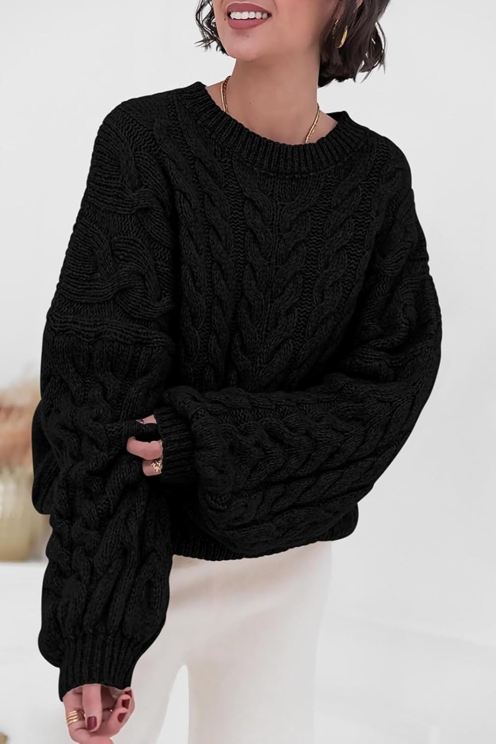 Mila Black cable-knit crewneck sweater shown from the front with ribbed neckline and cuffs.