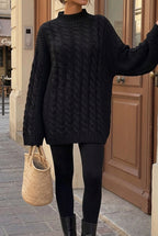 Mila Black cable-knit mock-neck sweater worn with black leggings and boots in a relaxed oversized fit.
