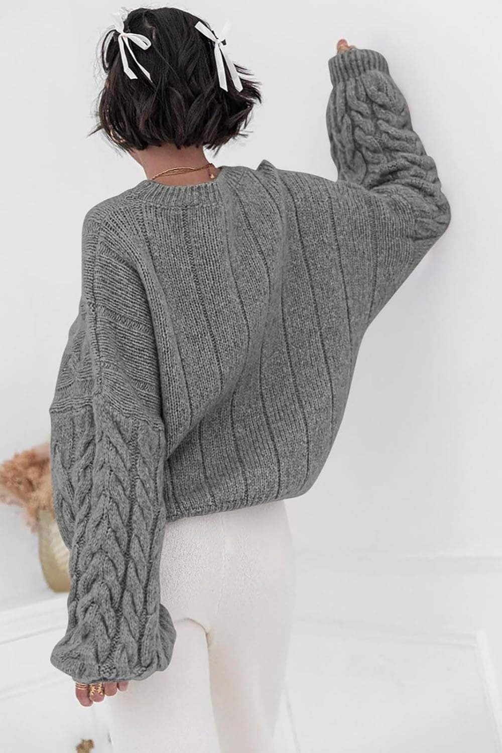 Mila Gray cable-knit sweater shown from the back with vertical ribbing and cable sleeves.