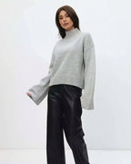 Mila Gray mock-neck sweater styled with black wide-leg pants in a three-quarter pose.