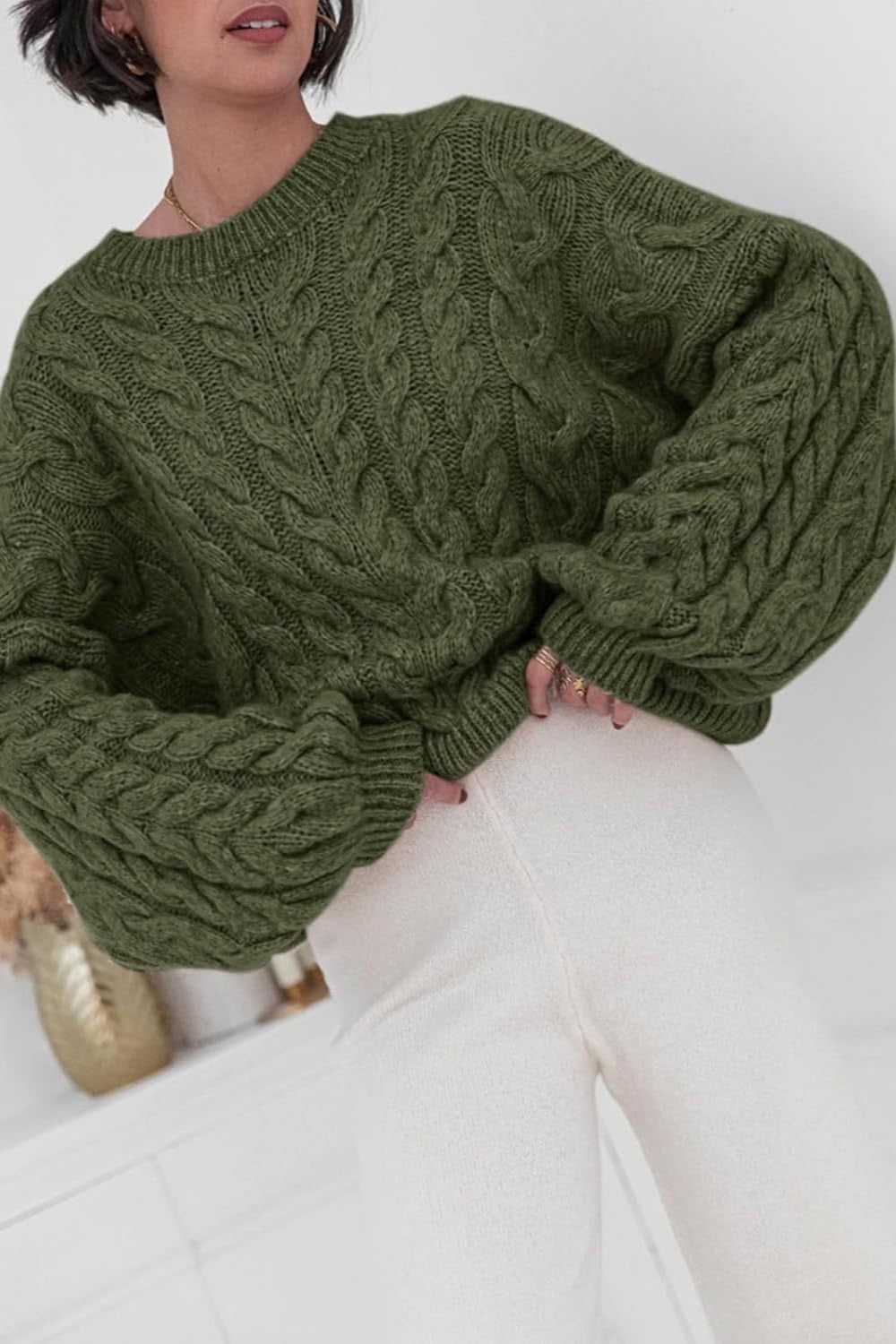 Mila Green cable-knit crewneck sweater shown close up with chunky cable texture.