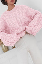 Mila Pink cable-knit crewneck sweater shown from the front with an oversized fit and cable sleeves.
