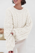 Mila White cable-knit crewneck sweater shown from the front with chunky cables and ribbed cuffs.