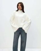 Mila White mock-neck sweater styled with wide-leg jeans in a full-length view.