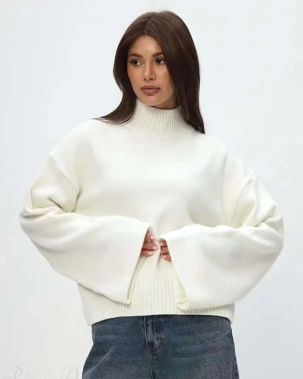Mila White mock-neck sweater with relaxed fit and wide flared sleeves styled with denim.