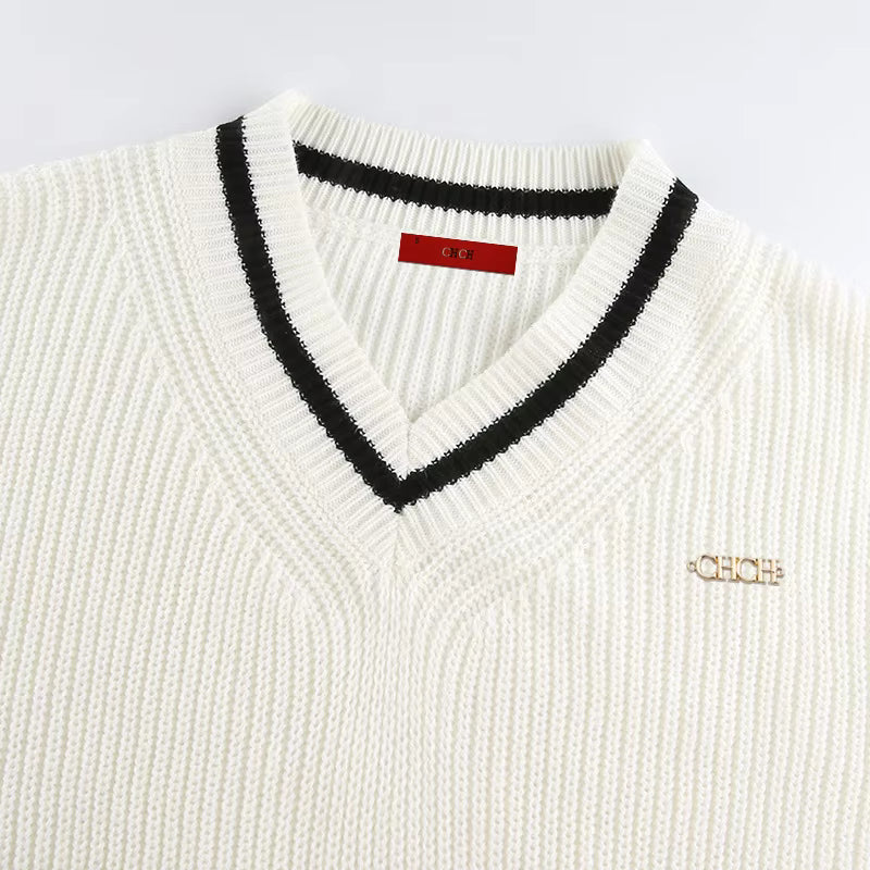 Close-up of Mila White knit sweater showing the double contrast V-neck trim and textured knit fabric
