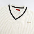 Close-up of Mila White knit sweater showing the double contrast V-neck trim and textured knit fabric