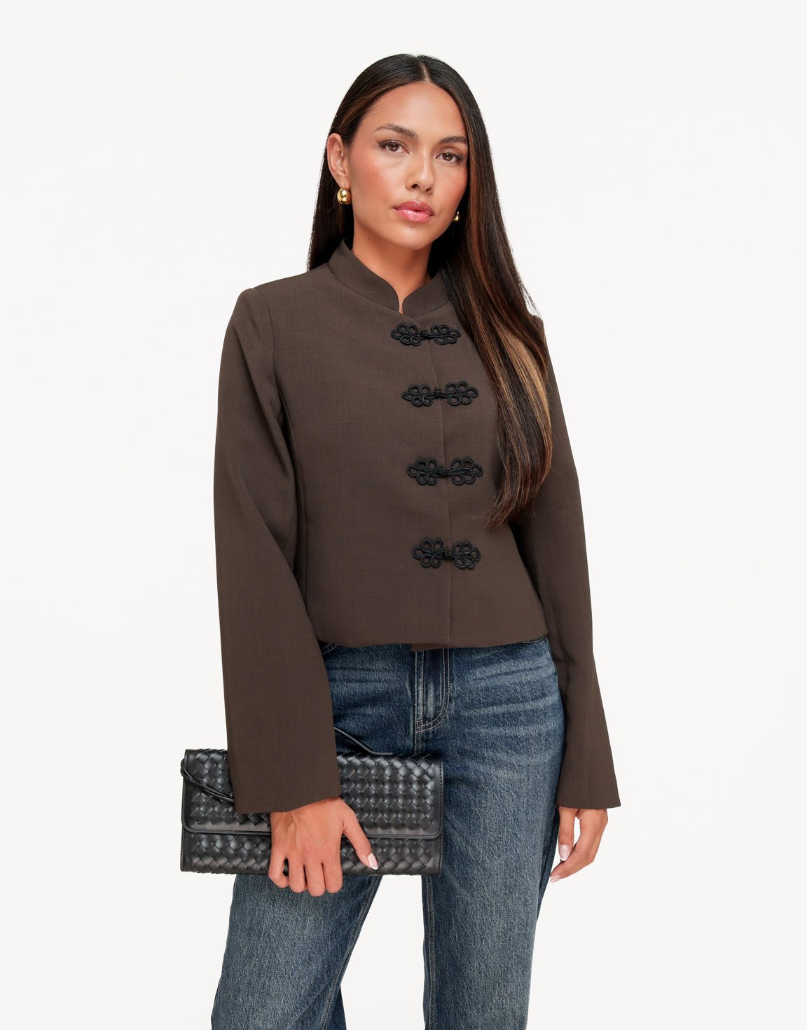 Mirela Dark Khaki cropped jacket with mandarin collar shown from the front while the model holds a woven black clutch.