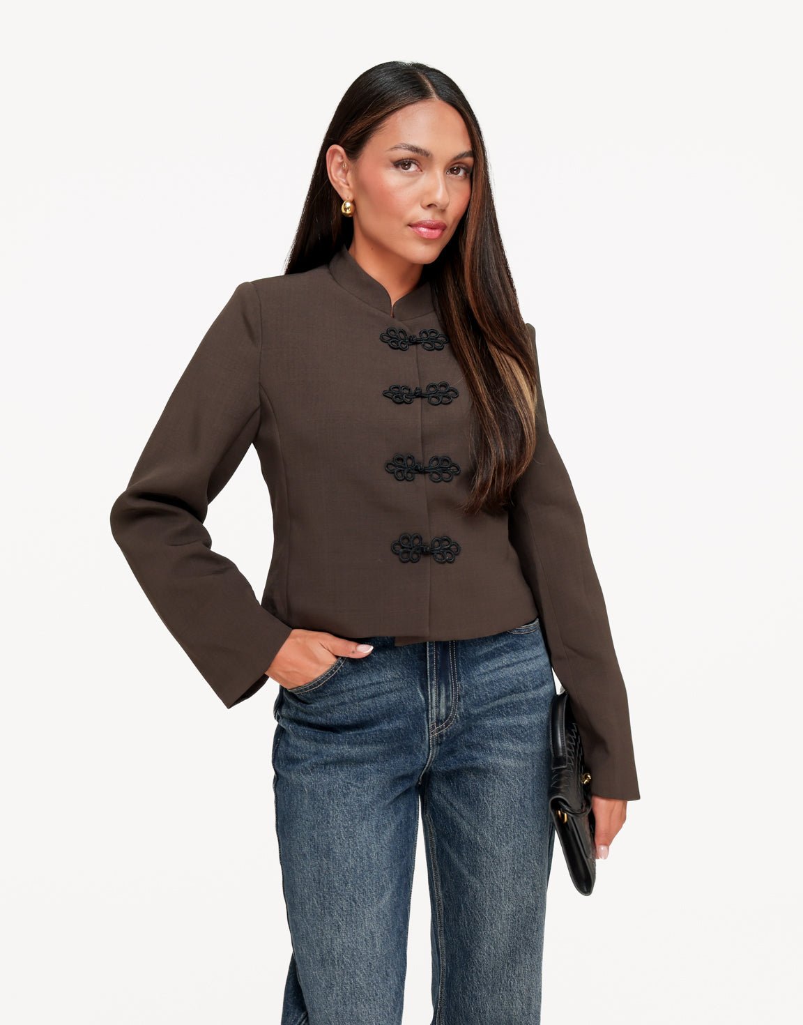 Mirela Dark Khaki frog closure jacket shown from the front with black frog-knot fastenings, styled with jeans and a black clutch.