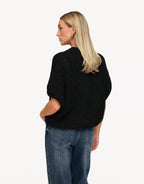 Nadine Black high neck knit sweater shown from the back with dropped shoulders and a rounded hem.
