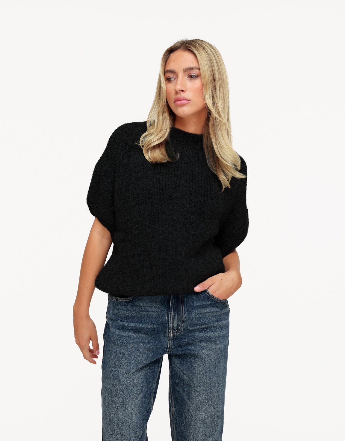 Nadine Black high neck knit sweater styled with straight-leg jeans, with the model looking to the side.