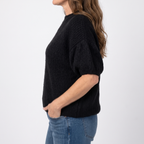 Nadine Black high neck knit sweater in side view showing the textured knit and gathered balloon sleeve.
