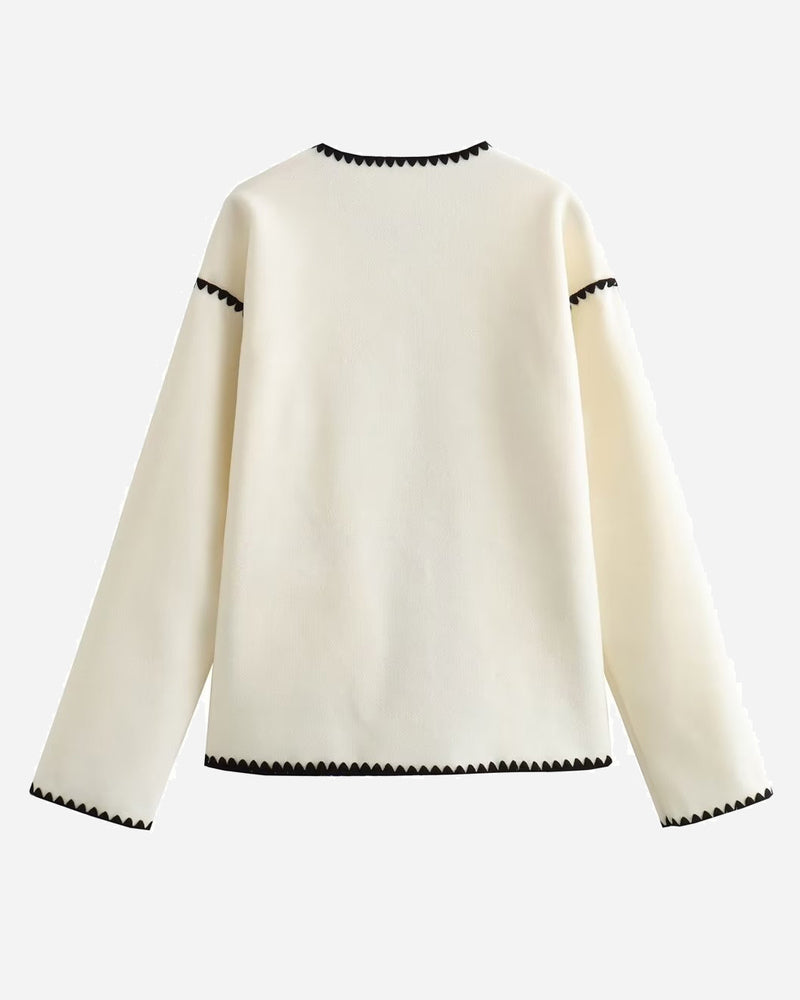 Nadorine White jacket back view with black stitched trim at the neckline and hem.