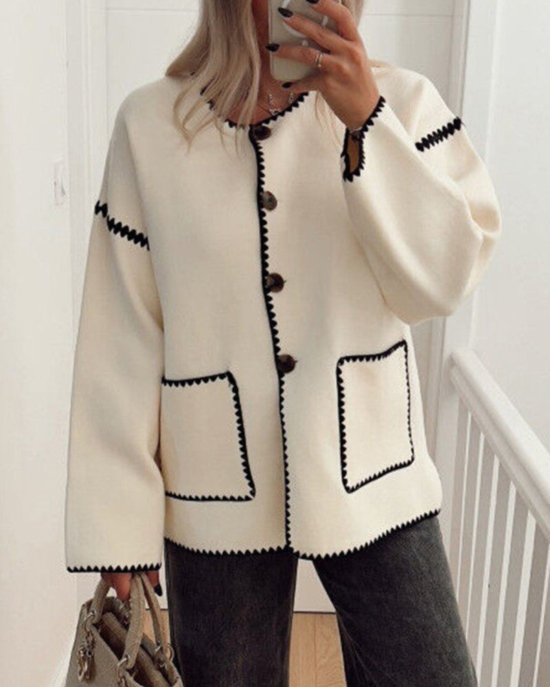 Nadorine White button-front jacket with black contrast stitching styled with gray wide-leg jeans.