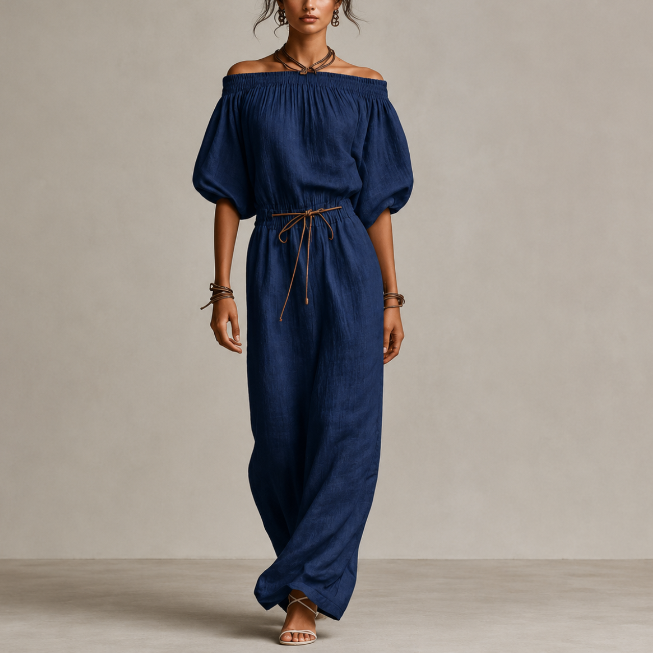 Noa Off-Shoulder Lightweight Linen Maxi Dress in dark blue featuring an off-shoulder neckline, lantern sleeves, adjustable waist tie, and flowing maxi-length silhouette. Designed by Bella Hudson.