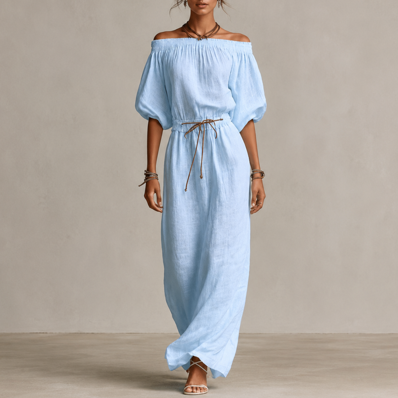 Noa Off-Shoulder Lightweight Linen Maxi Dress in sky blue featuring an off-shoulder neckline, lantern sleeves, adjustable waist tie, and flowing maxi-length silhouette. Designed by Bella Hudson.