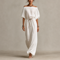 Noa Off-Shoulder Lightweight Linen Maxi Dress in white featuring an off-shoulder neckline, lantern sleeves, adjustable waist tie, and flowing maxi-length silhouette. Designed by Bella Hudson.