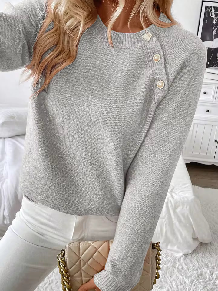 Nora Gray knit sweater with crew neckline, diagonal shoulder buttons, long sleeves, and relaxed silhouette