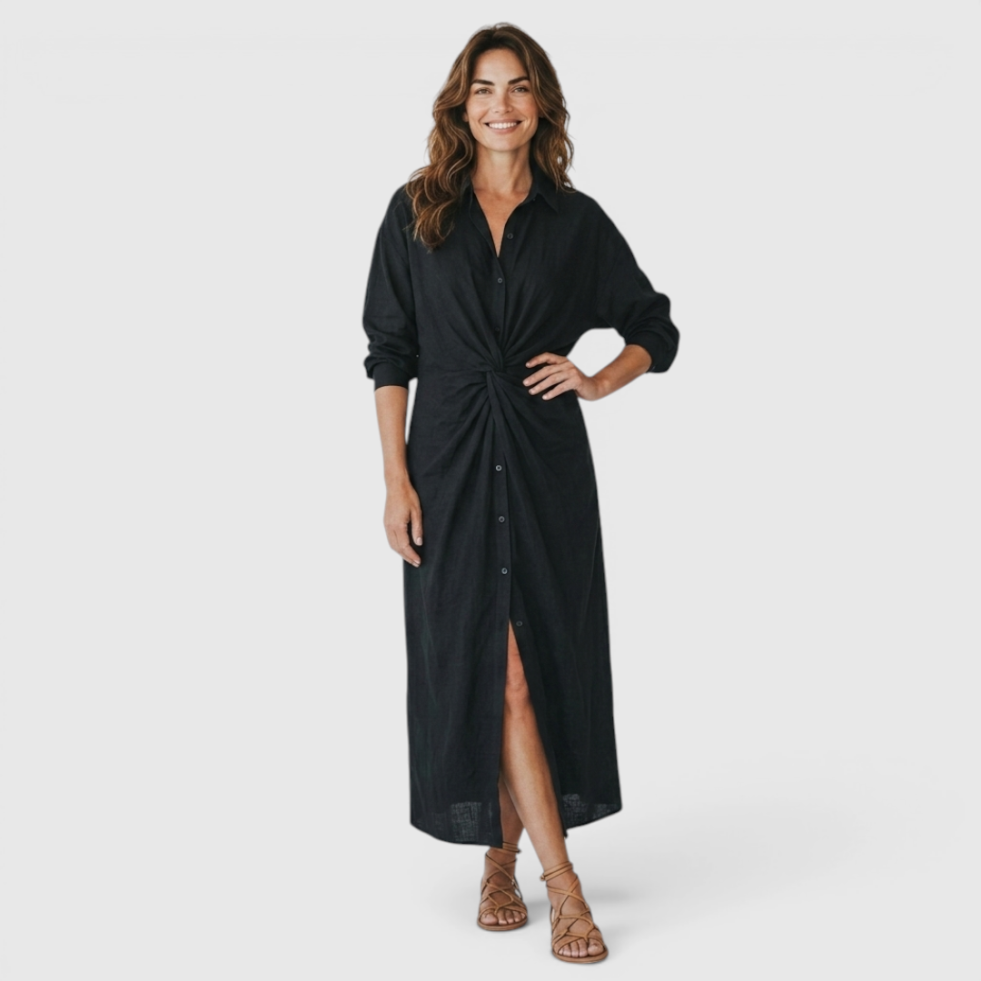 Front view of the Océane Shirt Dress Linen-Cotton Knot-Waist Maxi in black, featuring a collared neckline, button-front closure, long sleeves, knot-waist detail, front slit, and a flowing maxi silhouette. Designed by Bella Hudson.