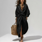 Lifestyle view of the Océane Shirt Dress Linen-Cotton Knot-Waist Maxi in black, showcasing the knot-waist detail, front slit, flowing silhouette, and effortless everyday styling. Designed by Bella Hudson.