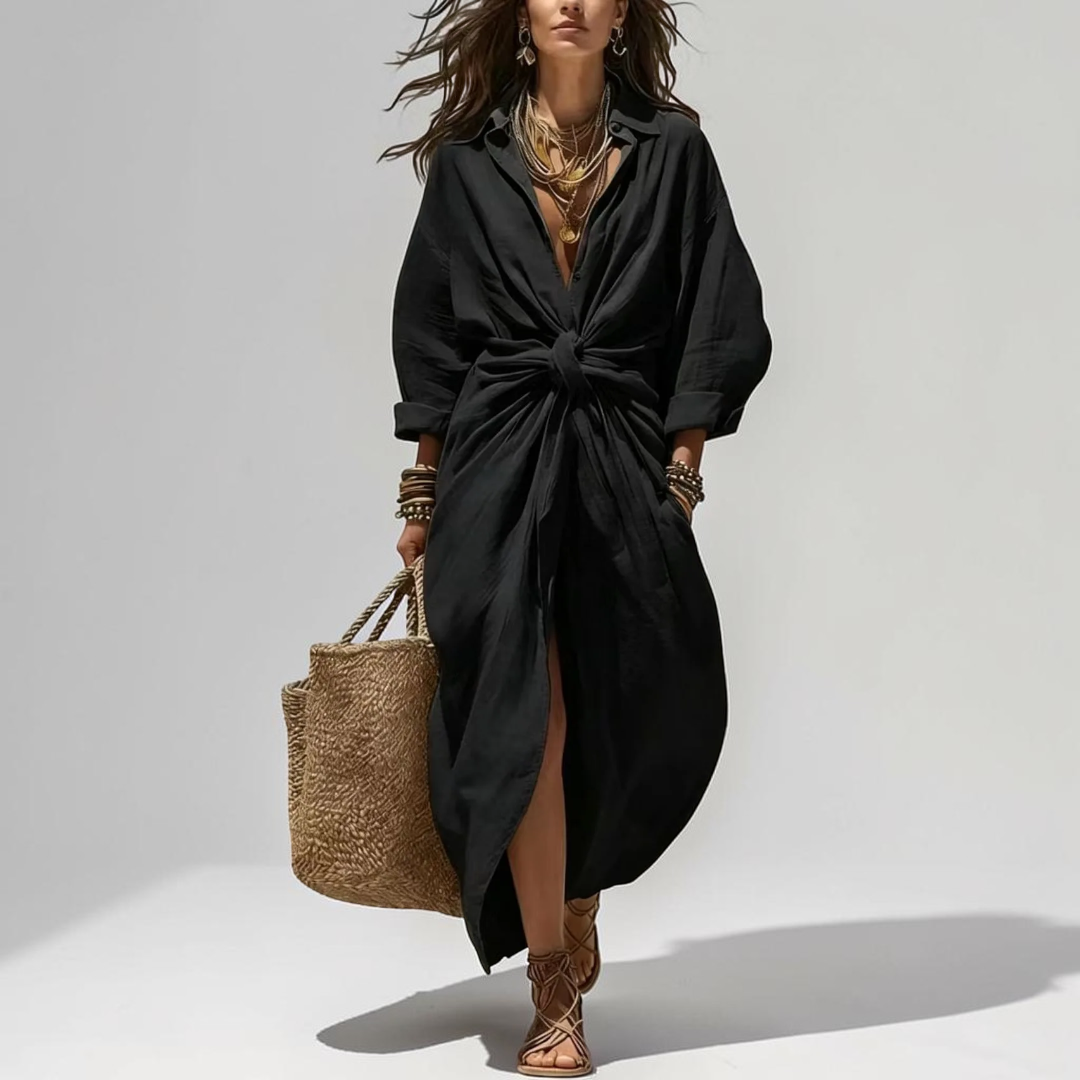 Lifestyle view of the Océane Shirt Dress Linen-Cotton Knot-Waist Maxi in black, showcasing the knot-waist detail, front slit, flowing silhouette, and effortless everyday styling. Designed by Bella Hudson.