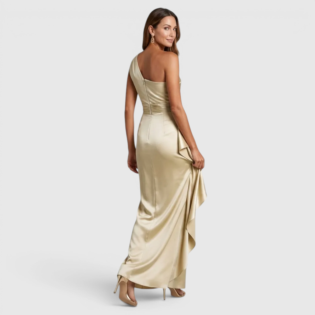 Back view of the Odessa Maxi Evening Dress Satin One-Shoulder Ruffle Style in champagne, highlighting the elegant one-shoulder design, smooth satin finish, and flowing maxi silhouette. Designed by Bella Hudson.