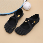 Odette Woman's Barefoot Flats Five-Toe Lightweight in Black shown in angle view, featuring a breathable upper, ergonomic five-toe design, flexible barefoot sole, lightweight construction, and wide toe box, designed by Bella Hudson.