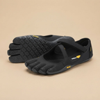 Odette Woman's Barefoot Flats Five-Toe Lightweight in Black shown in front view, featuring an ergonomic five-toe design, breathable upper, flexible barefoot sole, wide toe box, and lightweight comfort, designed by Bella Hudson.