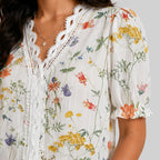 Close-up view of orange floral button blouse with short sleeves and floral print by BELLA HUDSON