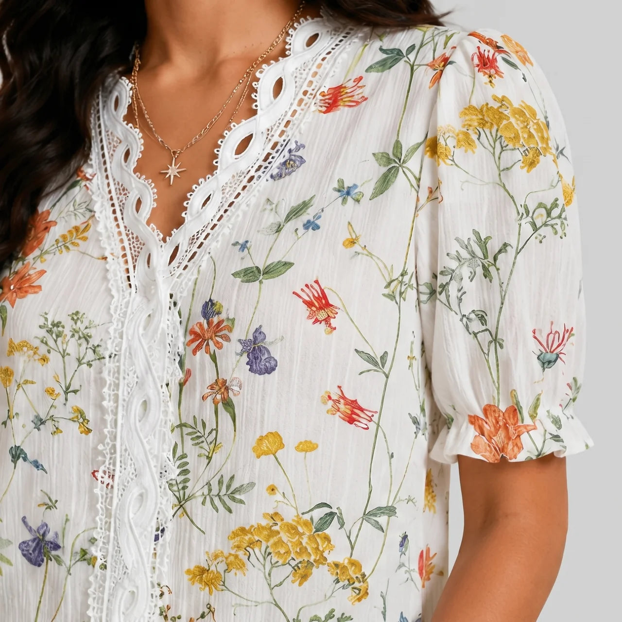 Close-up view of orange floral button blouse with short sleeves and floral print by BELLA HUDSON