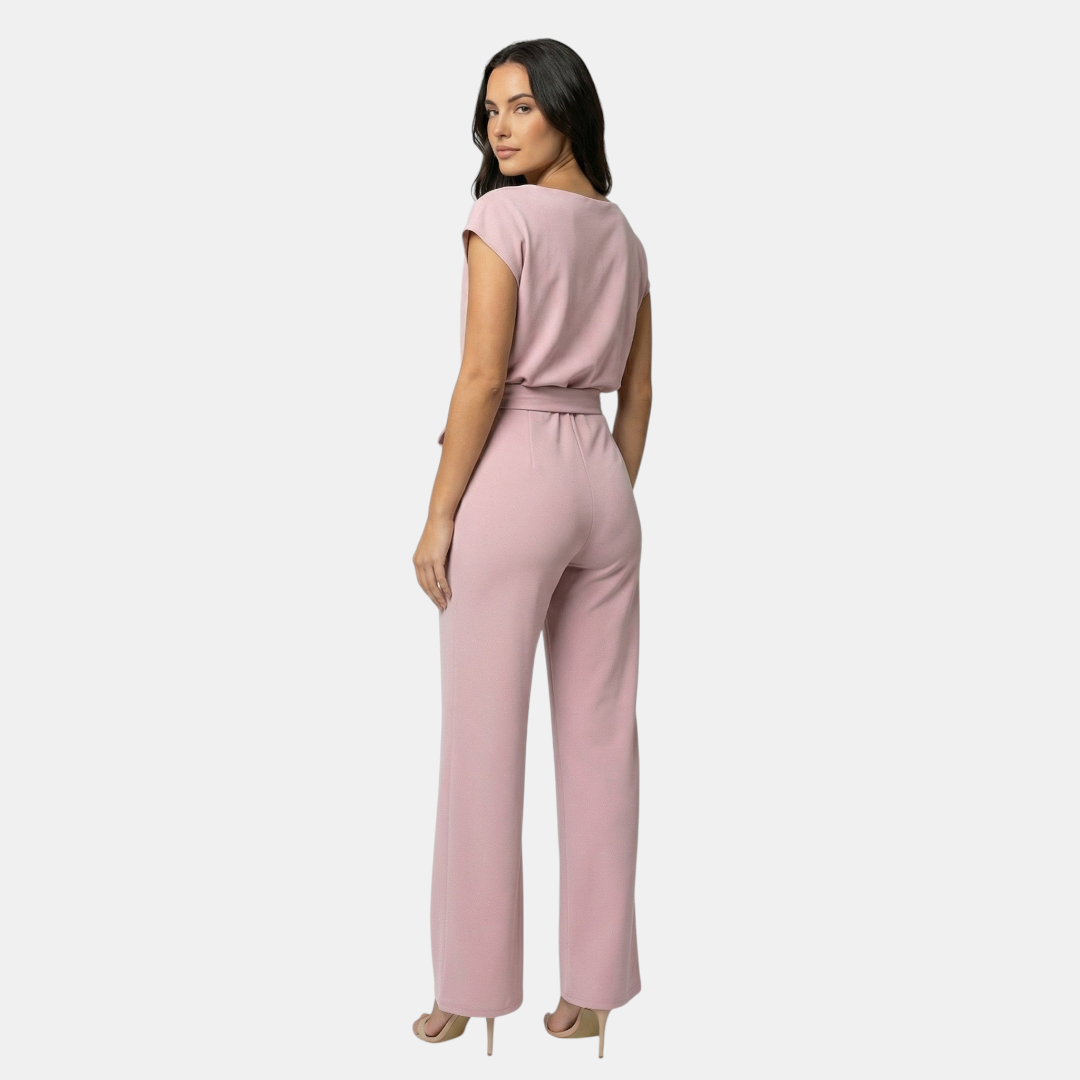 Back view of the Paloma Jumpsuit Wide-Leg Tie-Waist in pink, highlighting the relaxed silhouette, cap sleeves, elastic waist, and wide-leg design. Designed by Bella Hudson.