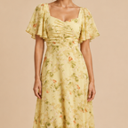 Close-up detail of the Patrice Floral Chiffon Maxi Dress in yellow featuring flutter sleeves and floral print. Designed by Bella Hudson.