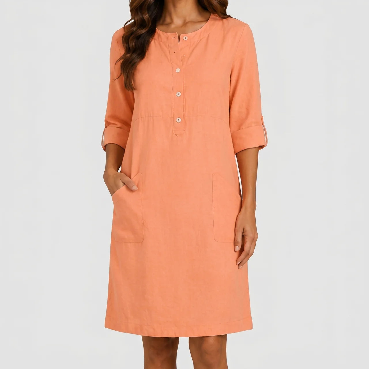 Front view of peach linen midi dress with rolled sleeves and side pockets by BELLA HUDSON