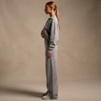 Side view of the Perpetua Two-Piece Set Knit Collared in Grey, showcasing its relaxed fit and matching wide-leg bottoms. Designed by Bella Hudson.