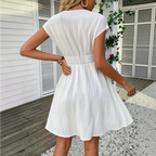 Lifestyle back view of the Philippa Fit-and-Flare Dress Lace-Trim Puff-Sleeve Striped in white, highlighting the fitted waist and flowing skirt from the rear. Designed by Bella Hudson.