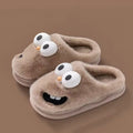 Poppy Brown plush house slippers with oversized 3D googly eyes, smiling cartoon faces, soft lining, and rounded closed toes