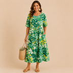 Front view of the Primrose Floral-Print A-Line Midi Dress Lightweight in green, featuring a vibrant floral print, relaxed A-line silhouette, round neckline, and lightweight fabric. Designed by Bella Hudson.