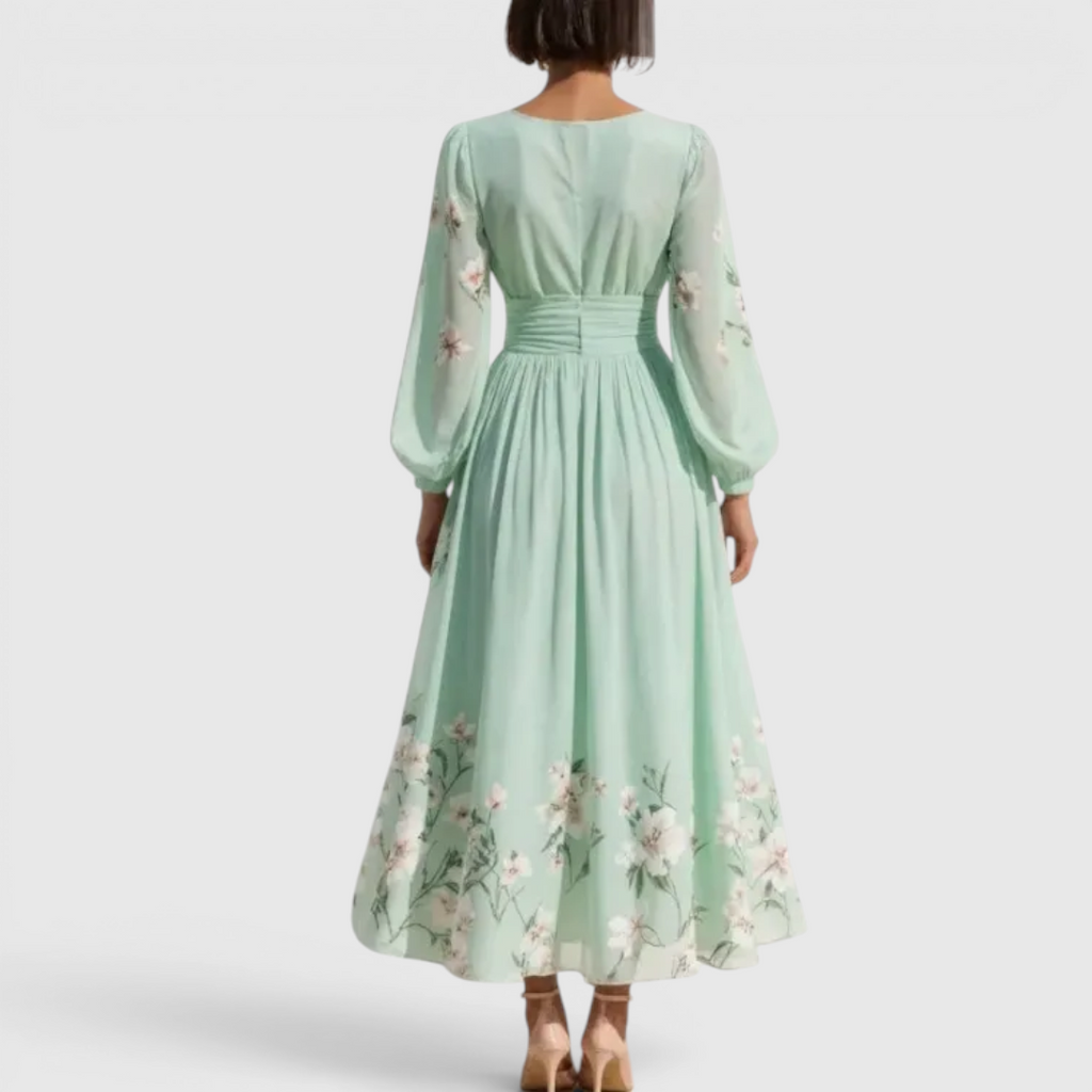 Back view of the Rosalie Midi Dress Floral-Print Chiffon Pleated V-Neck in light green, highlighting the long bishop sleeves, flowing pleated skirt, and elegant floral-print silhouette. Designed by Bella Hudson.