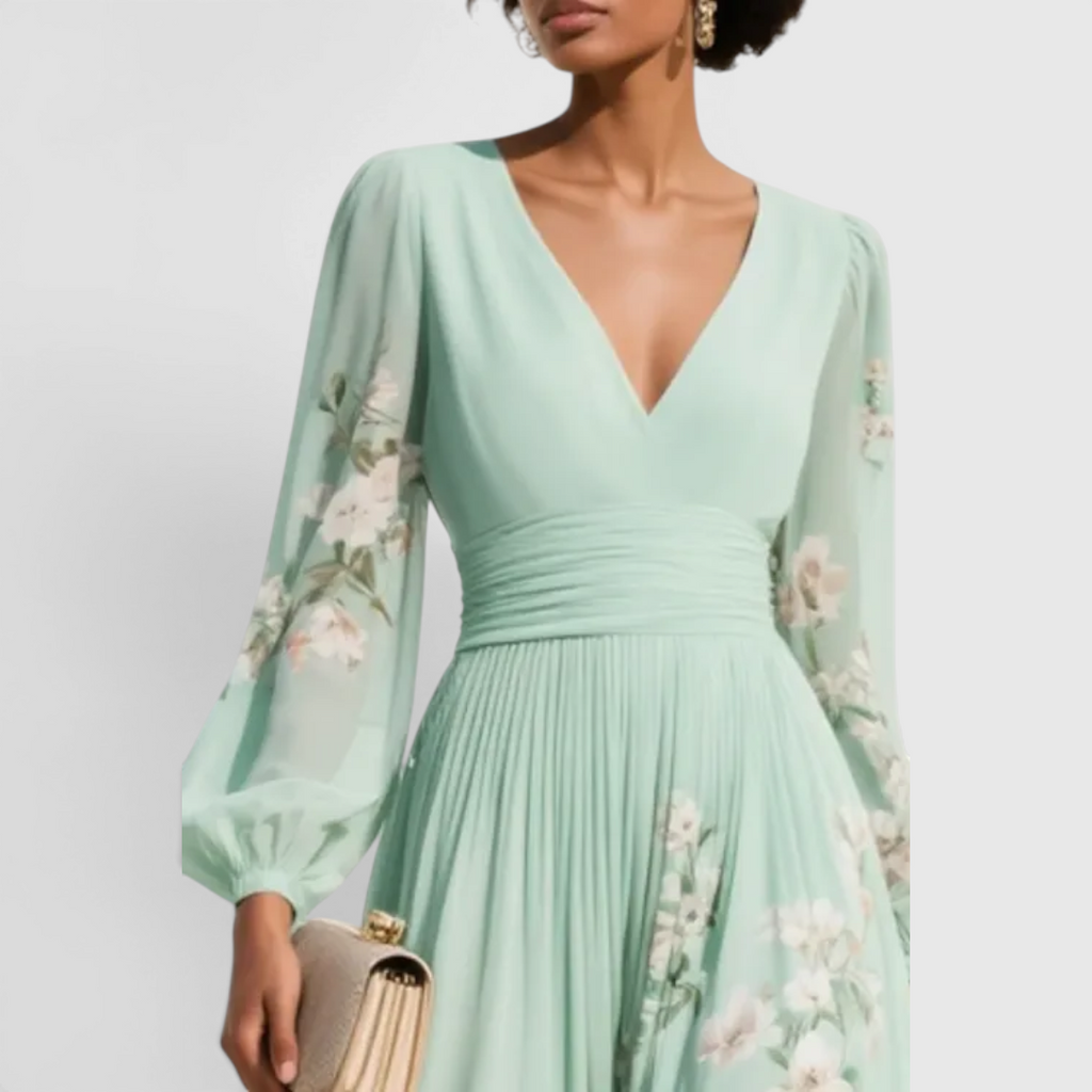 Close-up detail of the Rosalie Midi Dress Floral-Print Chiffon Pleated V-Neck in light green, featuring the V-neckline, gathered waist, long bishop sleeves, and delicate floral-print chiffon fabric. Designed by Bella Hudson.