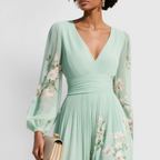 Close-up detail of the Rosalie Midi Dress Floral-Print Chiffon Pleated V-Neck in light green, featuring the V-neckline, gathered waist, long bishop sleeves, and delicate floral-print chiffon fabric. Designed by Bella Hudson.
